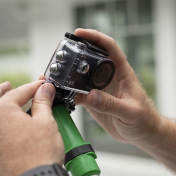 Persons hands mounting a high-definition gutter inspection camera on a pole.